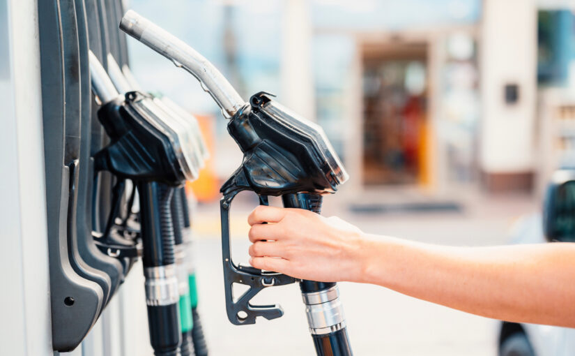 Closeup of woman pumping gasoline fuel in car at gas station. Pe