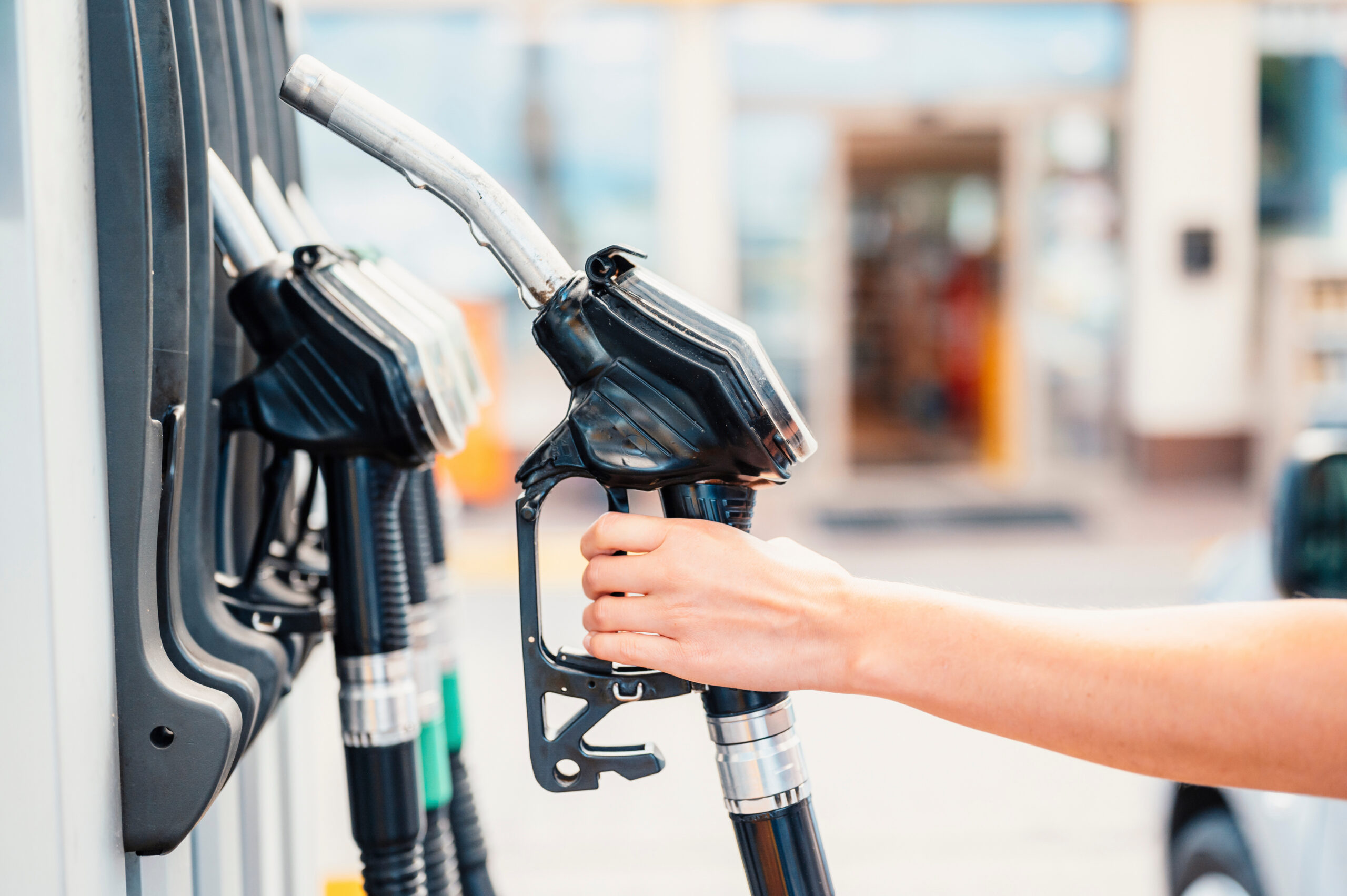 Closeup of woman pumping gasoline fuel in car at gas station. Pe